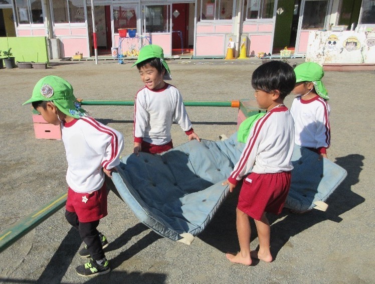 年中ばら組2学期年中児が友達と一緒に力を合わせてマットを運んでいます。