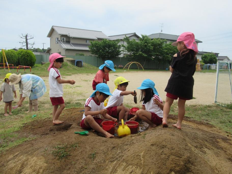 泥遊びをする園児