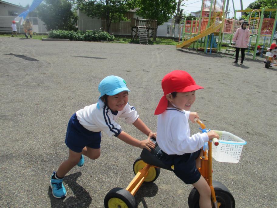 【大富幼稚園】年中児の三輪車を押してあげる年長児