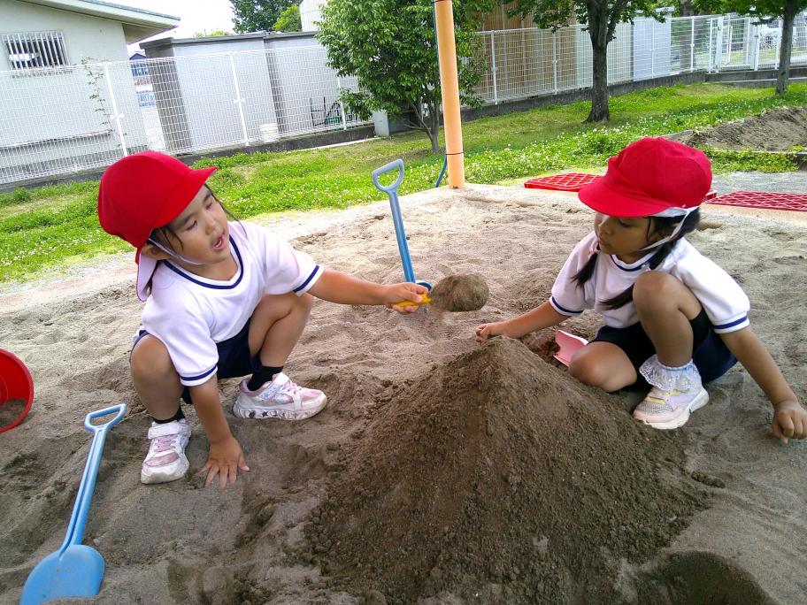 大富幼稚園、砂場で友達と一緒に山を作っている様子
