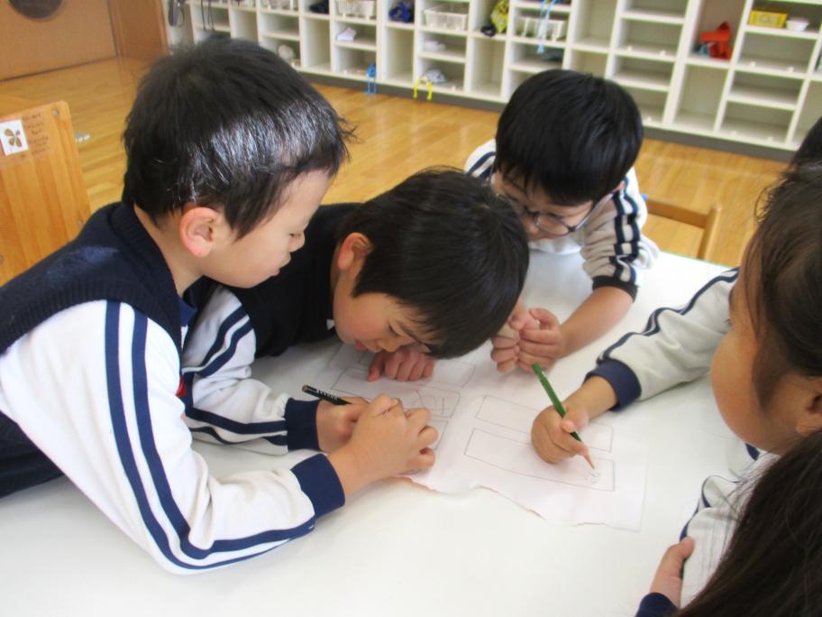 大富幼稚園、友達と一緒に文字を書いて遊んでいる年長児。